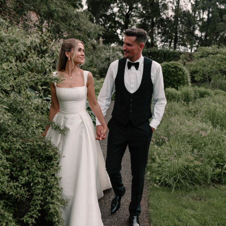 Bride and Groom at Middleton Lodge Estates walking through garden.
