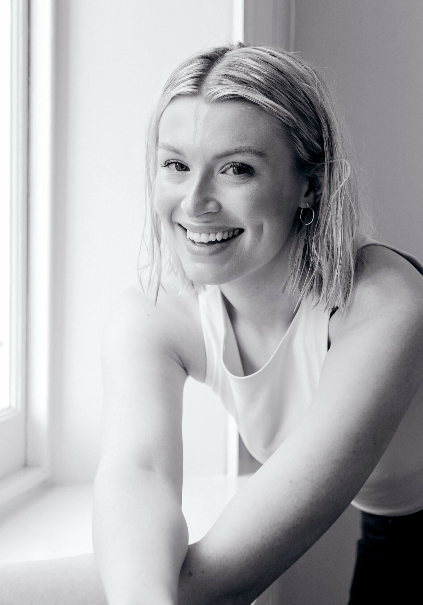 Image of Phoebe Lenderyou UK luxury wedding photographer next to window at wedding venue.